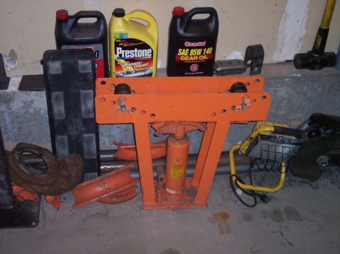 1995 Ford Bronco - Various automotive fluids and repair equipment are arranged on a concrete floor.