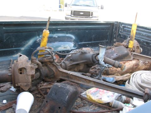 1995 Ford F-150 - Front axle assembly, likely from a truck, is loaded into the bed of another pickup truck.