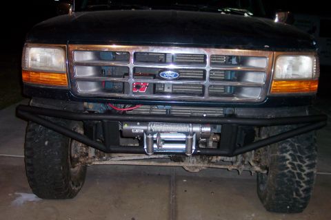 1995 Ford Bronco - Front view of a dark-colored Ford truck an aftermarket bumper and winch.