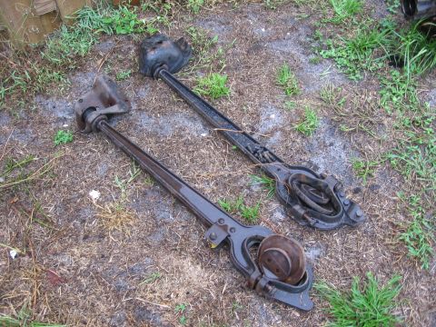 1995 Ford F-150 - Two vintage brake drum pullers are shown resting on the ground outdoors.