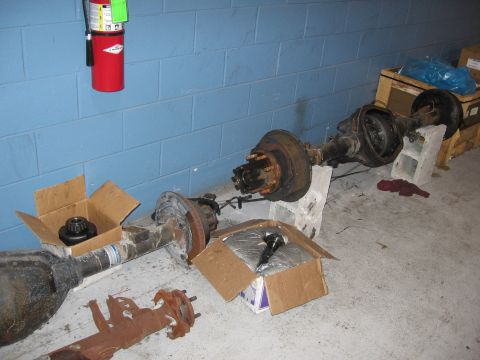 1995 Ford F-150 - Vehicle rear axles are shown on the floor, with a fire extinguisher mounted on the wall above.