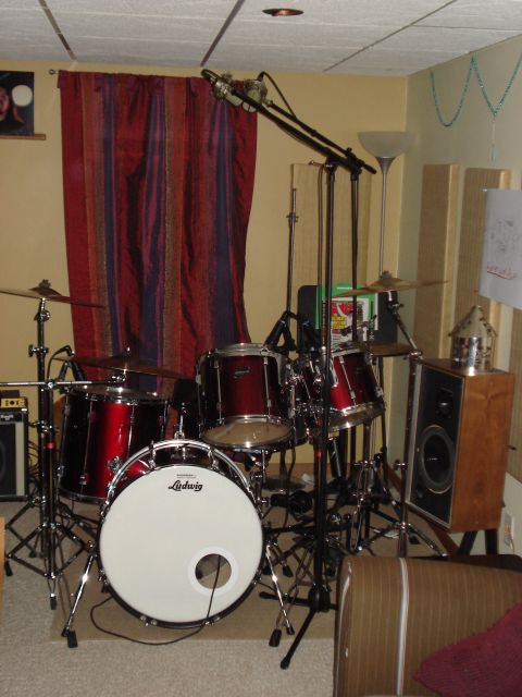 1986 Ford Bronco - A red drum kit is set up with microphones and a speaker, suggesting a music recording space.