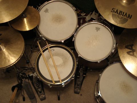 1986 Ford Bronco - A drum kit is shown from a top-down perspective, with drumsticks resting on a snare drum.