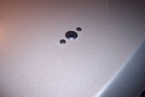 2001 Ford Crown Victoria - Three rear parking sensors are visible on the metallic silver bumper of a vehicle.
