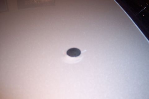 2001 Ford Crown Victoria - A close-up view of a car's interior surface reveals a small, dark circular element.