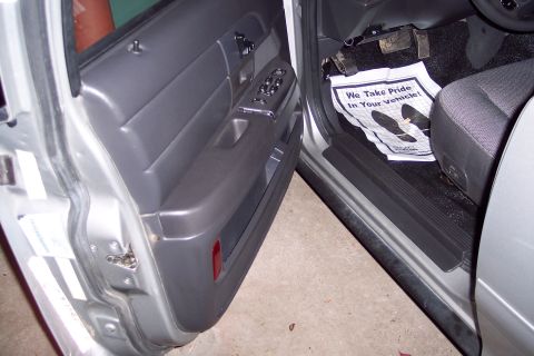 2001 Ford Crown Victoria - The interior of a 2001 Ford Crown Victoria, the driver's side door panel and a floor mat with the message 'We Take Pride In Your Vehicle!'.
