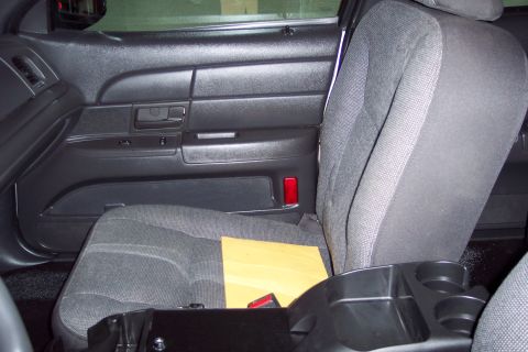 2001 Ford Crown Victoria - Interior view of a police car's front passenger seat and door panel, showing the fabric upholstery and black plastic trim.