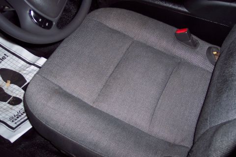 2001 Ford Crown Victoria - Interior view of a car seat and steering wheel, with a paper mat on the floor.
