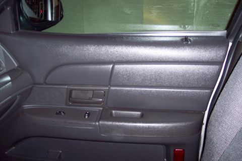 2001 Ford Crown Victoria - Interior view of a car's front passenger door panel, showing the armrest and window controls.