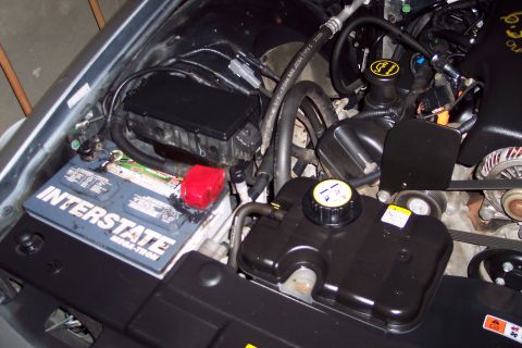 2001 Ford Crown Victoria - The engine bay features an Interstate Mega-Tron battery and a black coolant reservoir with yellow cap.