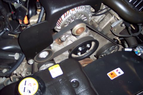 2001 Ford Crown Victoria - Close-up view of the engine bay, focusing on the belt system and alternator.