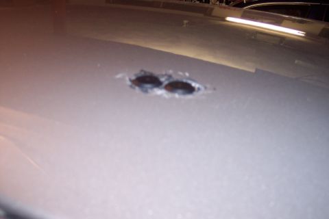 2001 Ford Crown Victoria - Close-up of two holes in the roof of a silver vehicle.