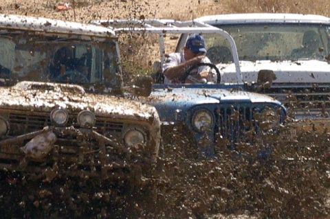 1990 Ford Bronco - Multiple off-road vehicles navigate a muddy terrain, with one 1978 Ford Bronco prominently featured.