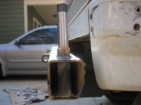 1996 Ford Bronco - Close-up of a home-fabricated square-tube bumper or shackle mount with a threaded steel post welded to the top, held in front of the mud-st…
