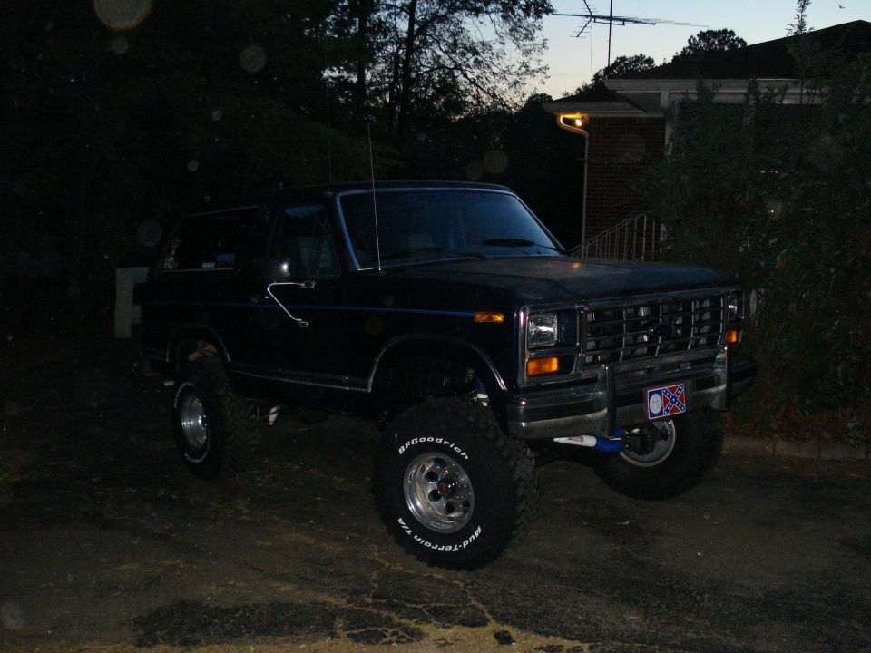 Black lifted 1984 Ford Bronco with BFGoodrich tires parked at dusk