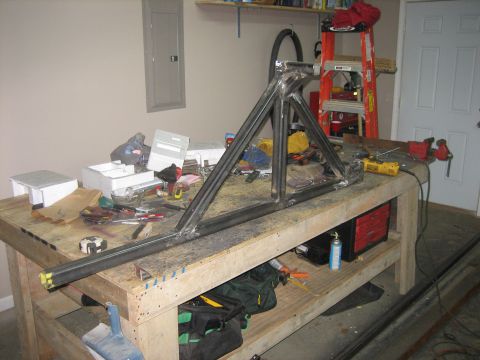 1996 Ford Bronco - A partially welded triangulated tube structure, the mockup of a fabricated bumper or roll-cage/tire-carrier section, clamped on a plywood w…