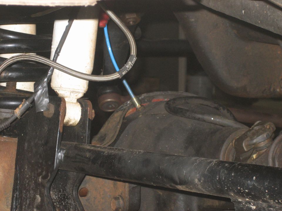 Underbody view of a leaf spring, braided brake line and axle