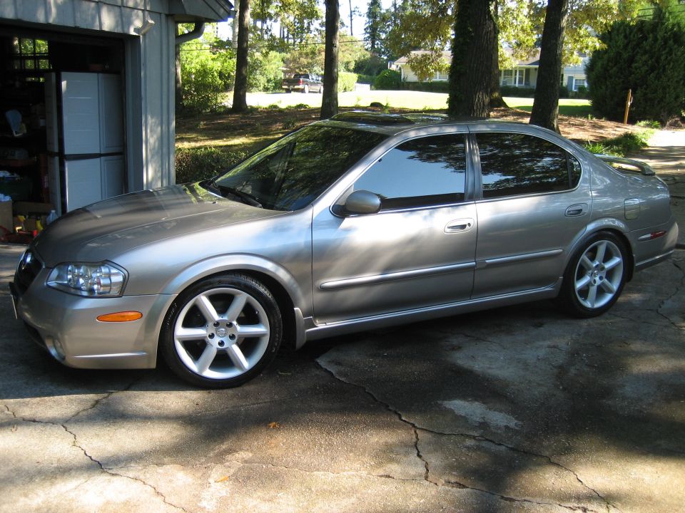 Silver four-door sedan, side view, tinted windows and alloy wheels in a driveway