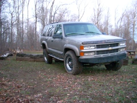 2000 Chevrolet Tahoe - This Chevrolet Tahoe SUV is parked outdoors in a wooded area during the fall season.