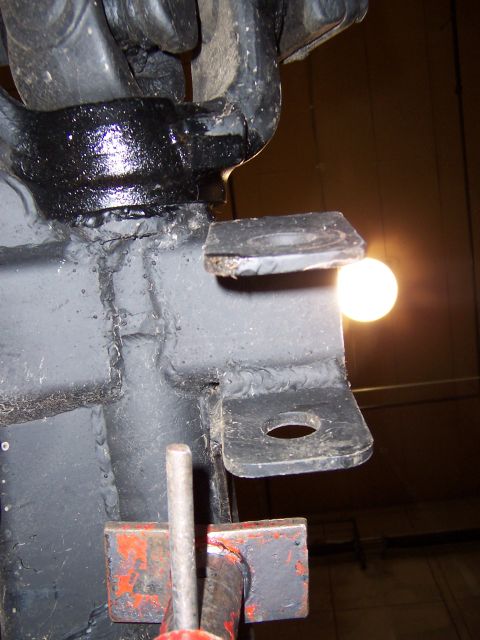 1990 Ford Bronco - Close-up of a vehicle's suspension part, with a light source visible in the background.