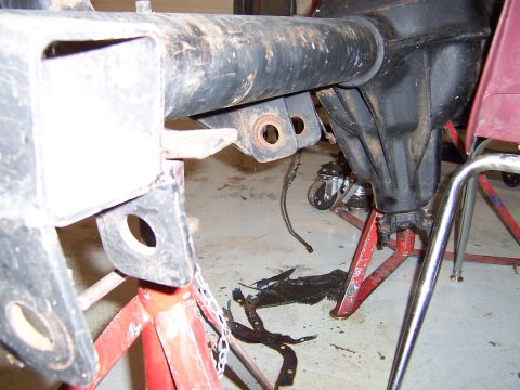 1990 Ford Bronco - A Dana 60 front axle assembly is shown supported by red jack stands in a workshop setting that appears to be a garage or workshop.
