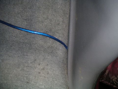 1994 Ford Bronco - A blue wire is visible on the carpet and trim inside a vehicle's interior.