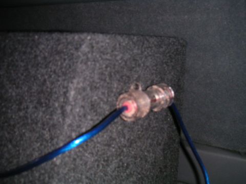 1994 Ford Bronco - Close-up of an audio cable connector attached to a carpeted surface, with a blue wire visible.