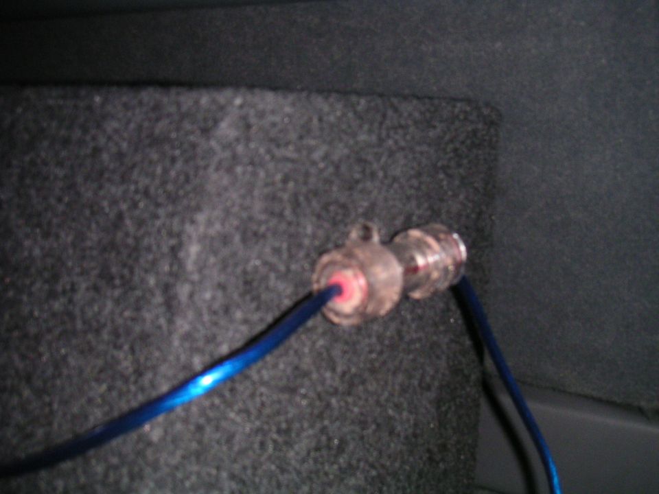 Audio cable connector with blue wire entering a carpeted enclosure