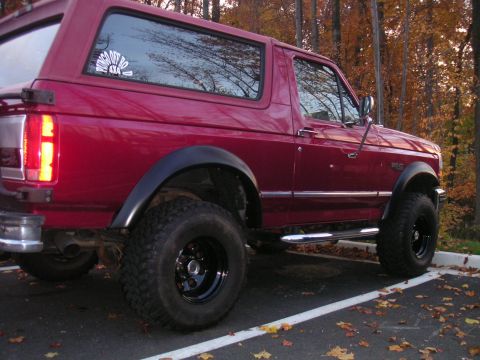 1994 Ford Bronco - This 1994 Ford Bronco is shown in a three-quarter rear view, highlighting its fender flares and red paint.