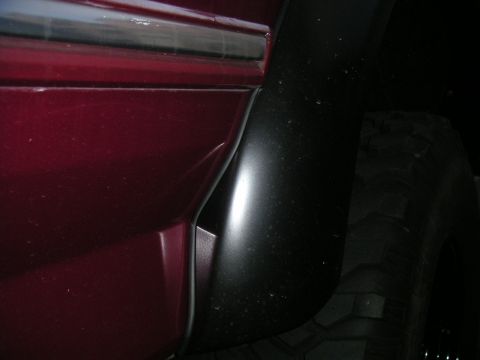 1994 Ford Bronco - Detail shot of a vehicle's fender flare and tire, with a partial view of the body panel.