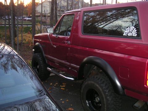1994 Ford Bronco - This 1994 Ford Bronco is seen from the side, its distinctive fender flares and a sun graphic on the rear window.
