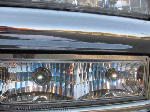 1994 Chevrolet Silverado 3500 - The headlights of a truck are shown in detail, reflecting light.
