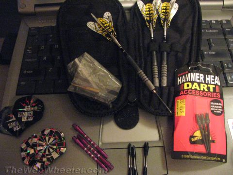 1968 Ford Mustang - A collection of darts and accessories, including a dart case and replacement points, are laid out on a laptop.