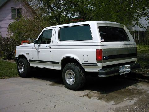 1987 Ford Bronco - This white 1987 Ford Bronco SUV is shown from the rear quarter angle.