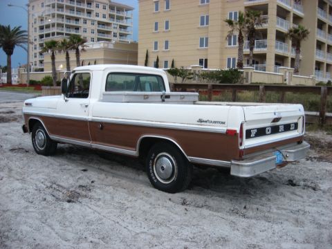 1972 Ford F-100 - Ford F-100 Sport Custom pickup truck parked on sand near beach buildings.
