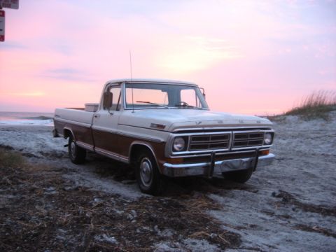 1972 Ford F-100 - A two-tone Ford F-100 sits on the sand as the sun sets over the ocean.