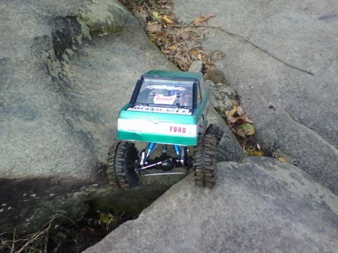 1996 Ford Bronco - A remote-controlled truck with 'FORD' text on its grille navigates a rocky terrain.