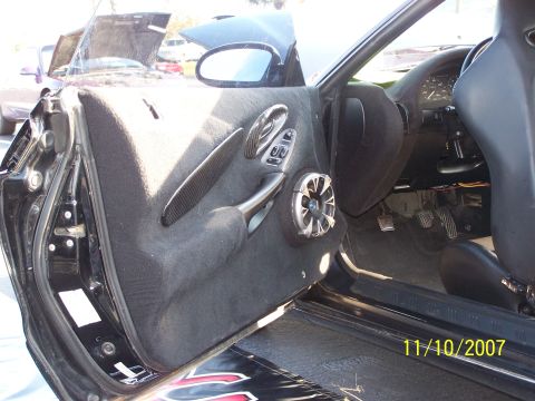 1995 Ford Probe - Interior view of a car's driver side door panel, showing custom speaker and door handle details.