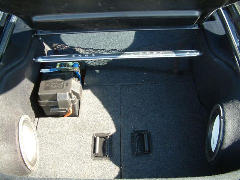 1995 Ford Probe - The interior of a car trunk is visible, equipped with subwoofers and a battery box.