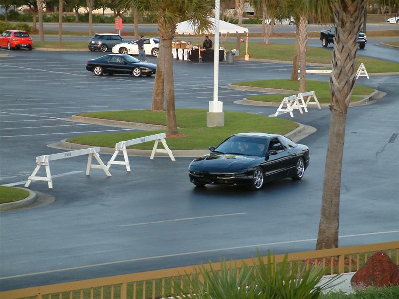 Black 1995 Ford Probe driving in a parking lot