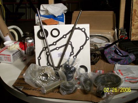 1988 Suzuki Samurai - A collection of engine parts, including gaskets and gears, are laid out on a surface.