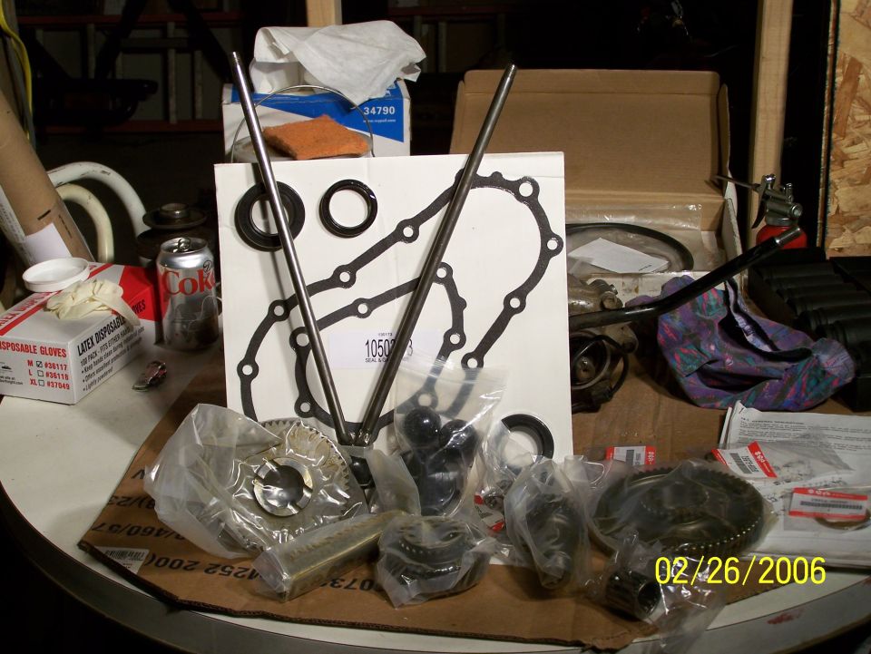 Engine gasket set and assorted internal engine parts in plastic bags and boxes on a table