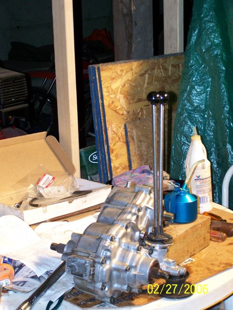 1988 Suzuki Samurai - A disassembled transfer case with dual shifter levers sits on a cluttered workbench.
