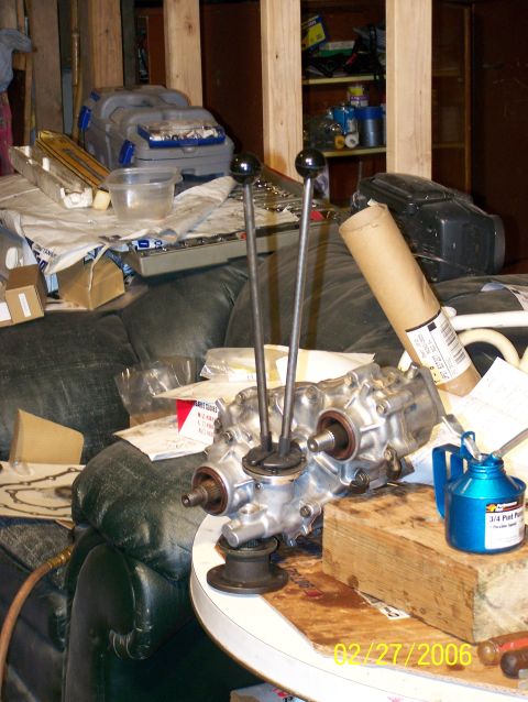 1988 Suzuki Samurai - Transfer case with twin sticks, likely for an off-road vehicle, sits on a table with an oil can.