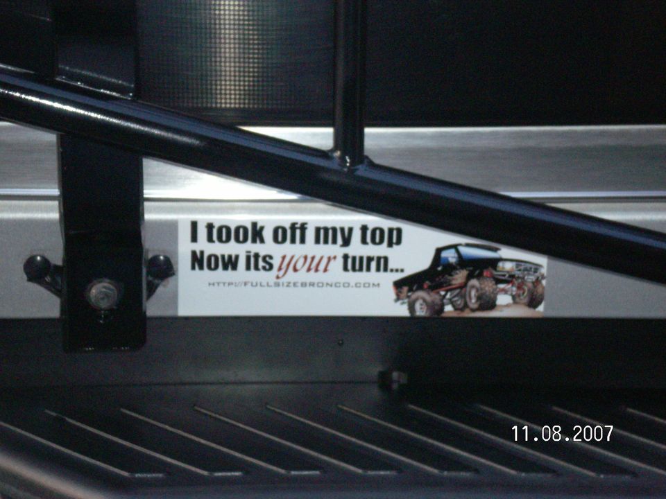 FullSizeBronco.com bumper sticker 'I took off my top, Now its your turn' on metal panel behind black tube framework