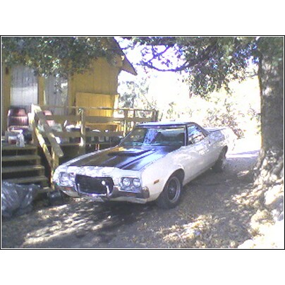 1972 Ford Ranchero - A 1972 Ford Ranchero GT is parked in a driveway next to a house and a large tree.