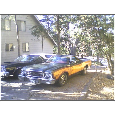 1973 Ford Ranchero - This 1973 Ford Ranchero features distinctive woodgrain paneling on its sides and is parked alongside another vehicle.