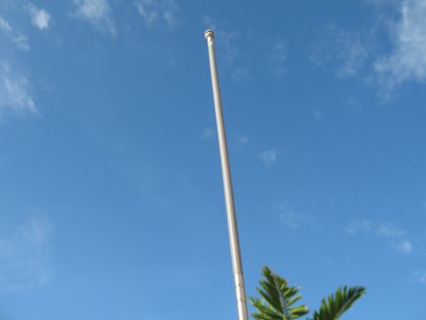 1994 Ford Bronco - A tall CB antenna extends towards the sky, with a few clouds and some greenery in view.