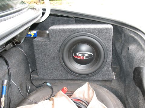 1997 Ford Crown Victoria - A car's trunk interior shows a subwoofer box and spare tire.