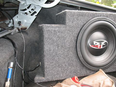 1997 Ford Crown Victoria - Subwoofer box installed in the trunk of a car, with wiring and other items present.